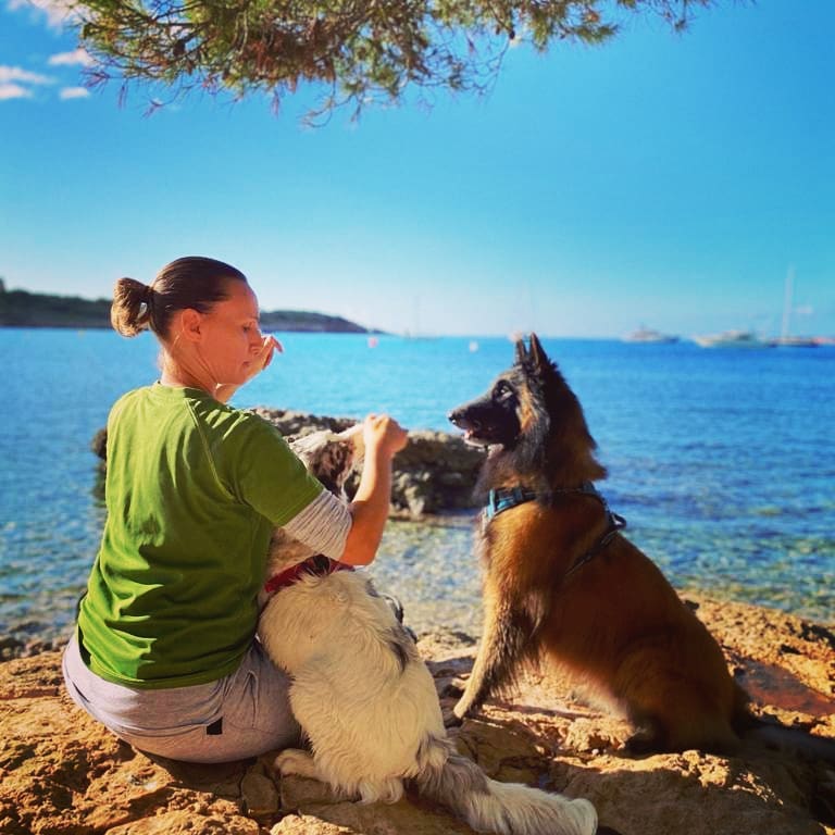 Puri Ots y su perro delante del mar en Mallorca